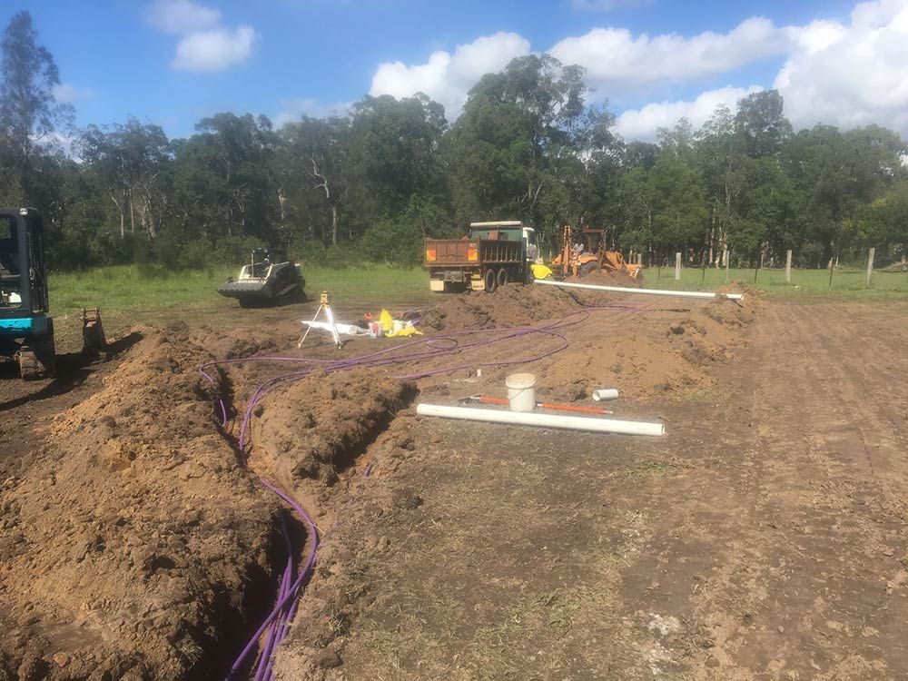 Construction Site With Trench, Purple Pipes — VR Marsden Plumbing in Urunga, NSW