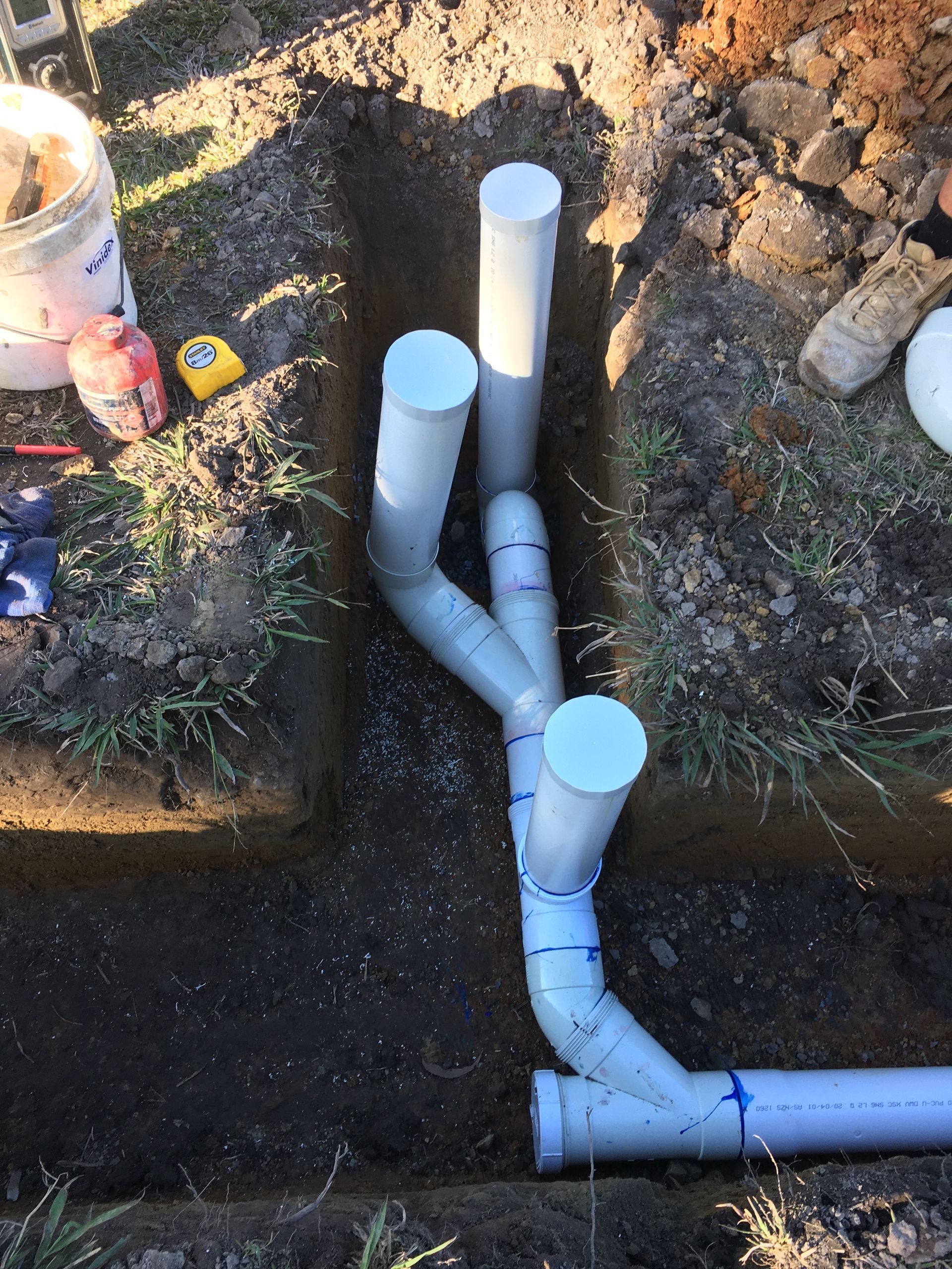 PVC plumbing pipes in a trench, ready for installation— VR Marsden Plumbing in Red Rock, NSW