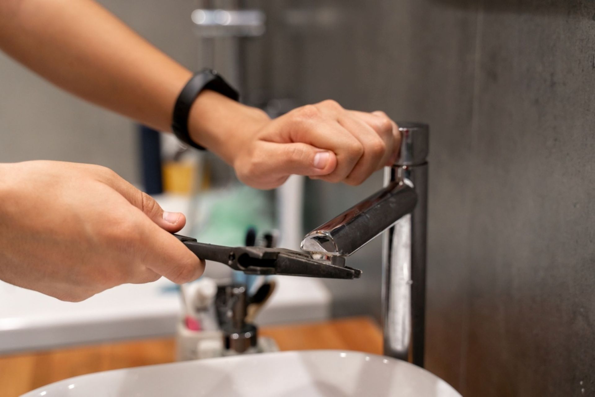 Person Using Pliers on a Faucet to Make a Repair; Bathroom Setting — VR Marsden Plumbing in Red Rock, NSW