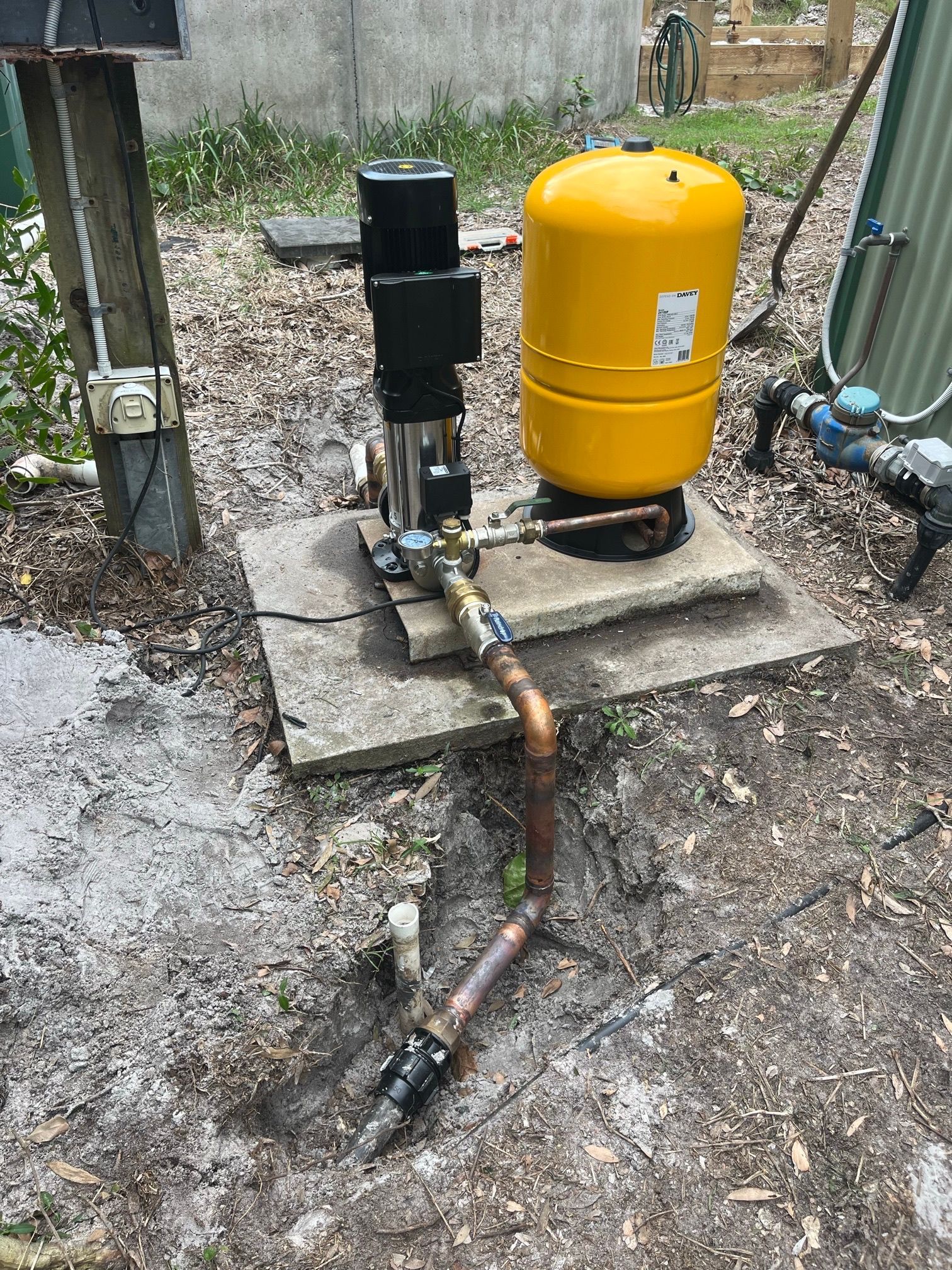 Fire pump system outdoors with a yellow pressure tank and copper pipes— VR Marsden Plumbing in Red Rock, NSW
