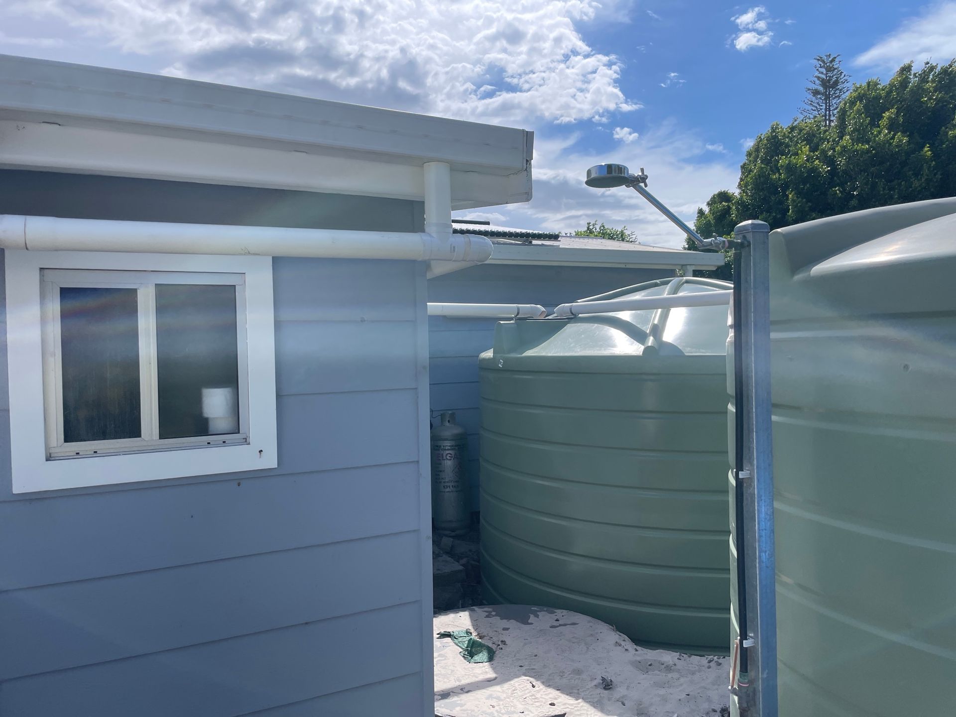 Two Large, Green Water Tanks  Outside a Building, Sunny Day — VR Marsden Plumbing in Red Rock, NSW
