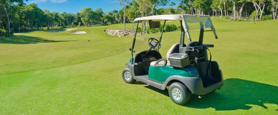 green golf buggy on sunny course