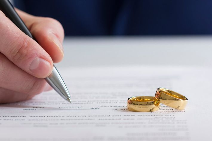 Man Signing a Paper With Wedding Rings