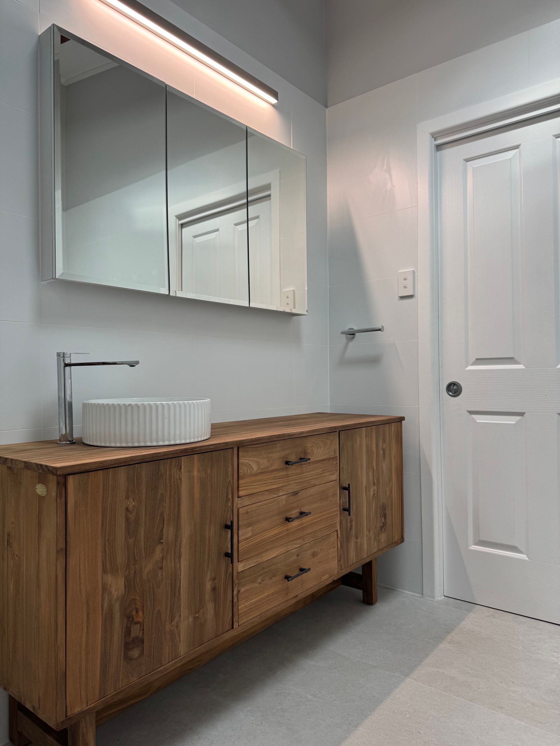 A bathroom with a wooden vanity and a sink — Hart Projects Wollongong In Dapto, NSW