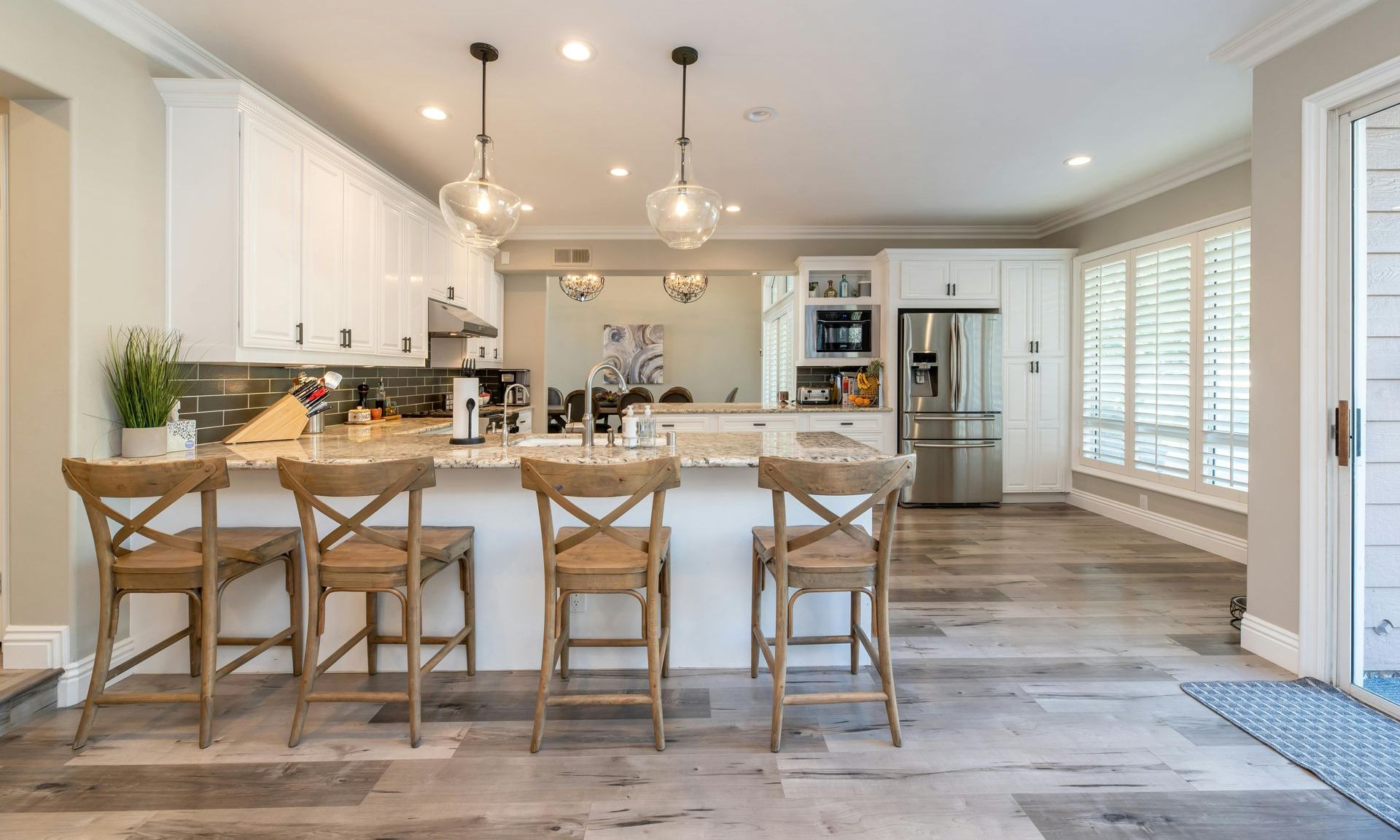 Modern kitchen with wooden bar stools and hanging lights  — Hart Projects Wollongong In Dapto, NSW