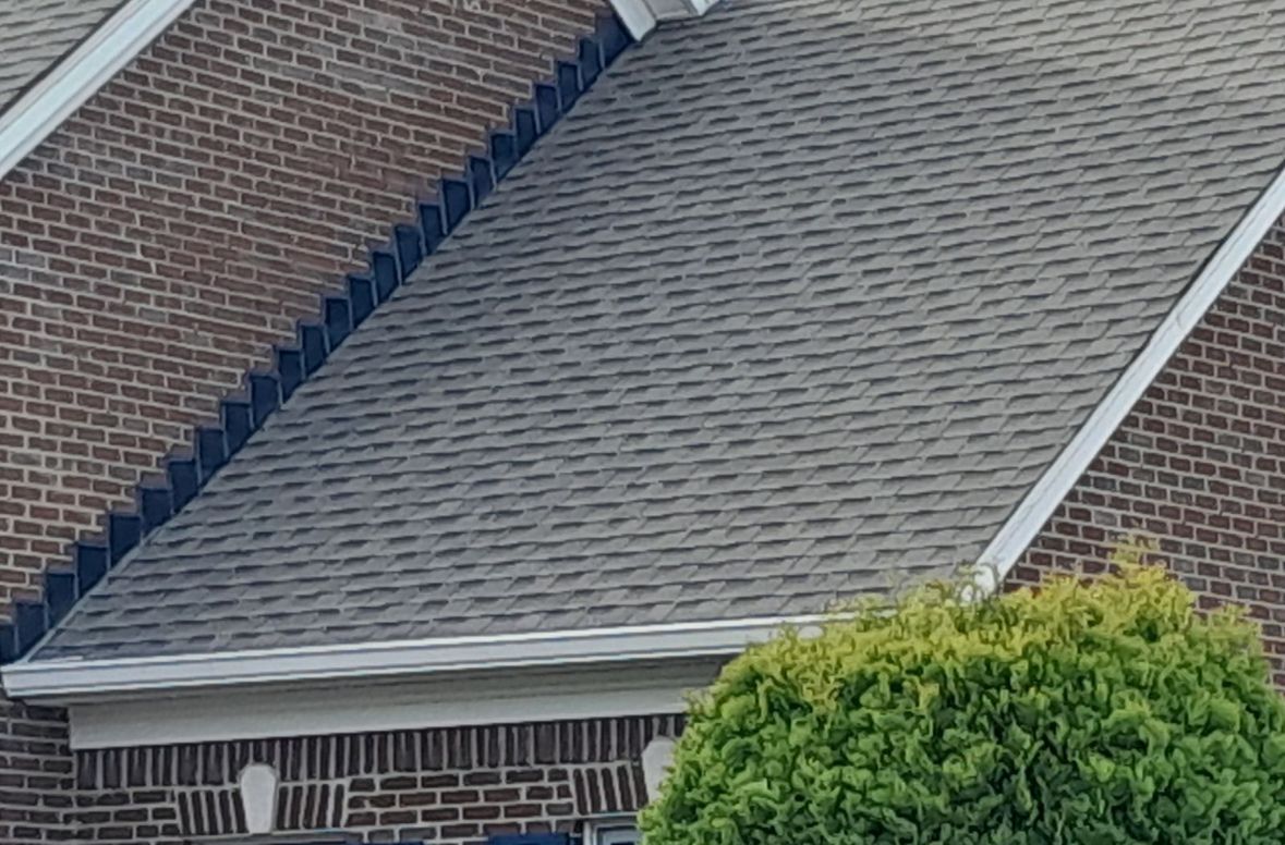 A brick house with a gray roof and a tree in front of it – Palmyra, IN - Dunn Remodeling Company