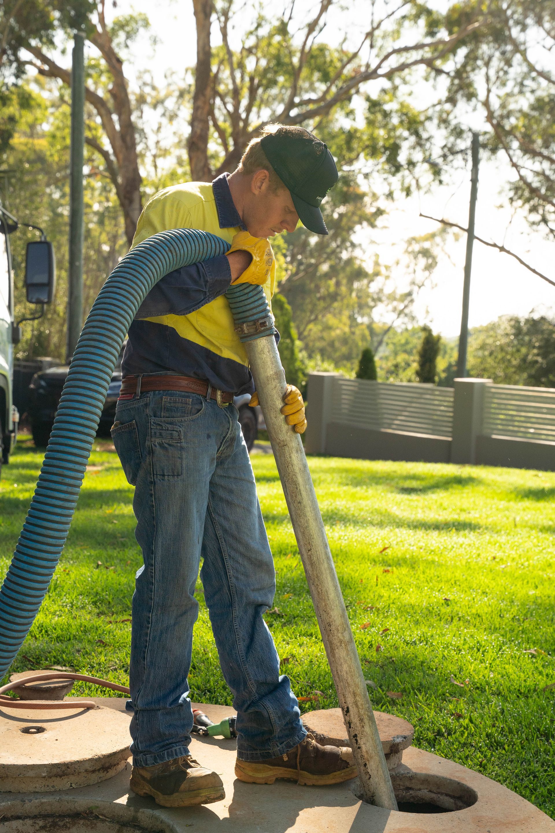 Worker Using a Vacuum Hose to Clean a Hole — Shreks Septic Services in Gowrie Junction, QLD
