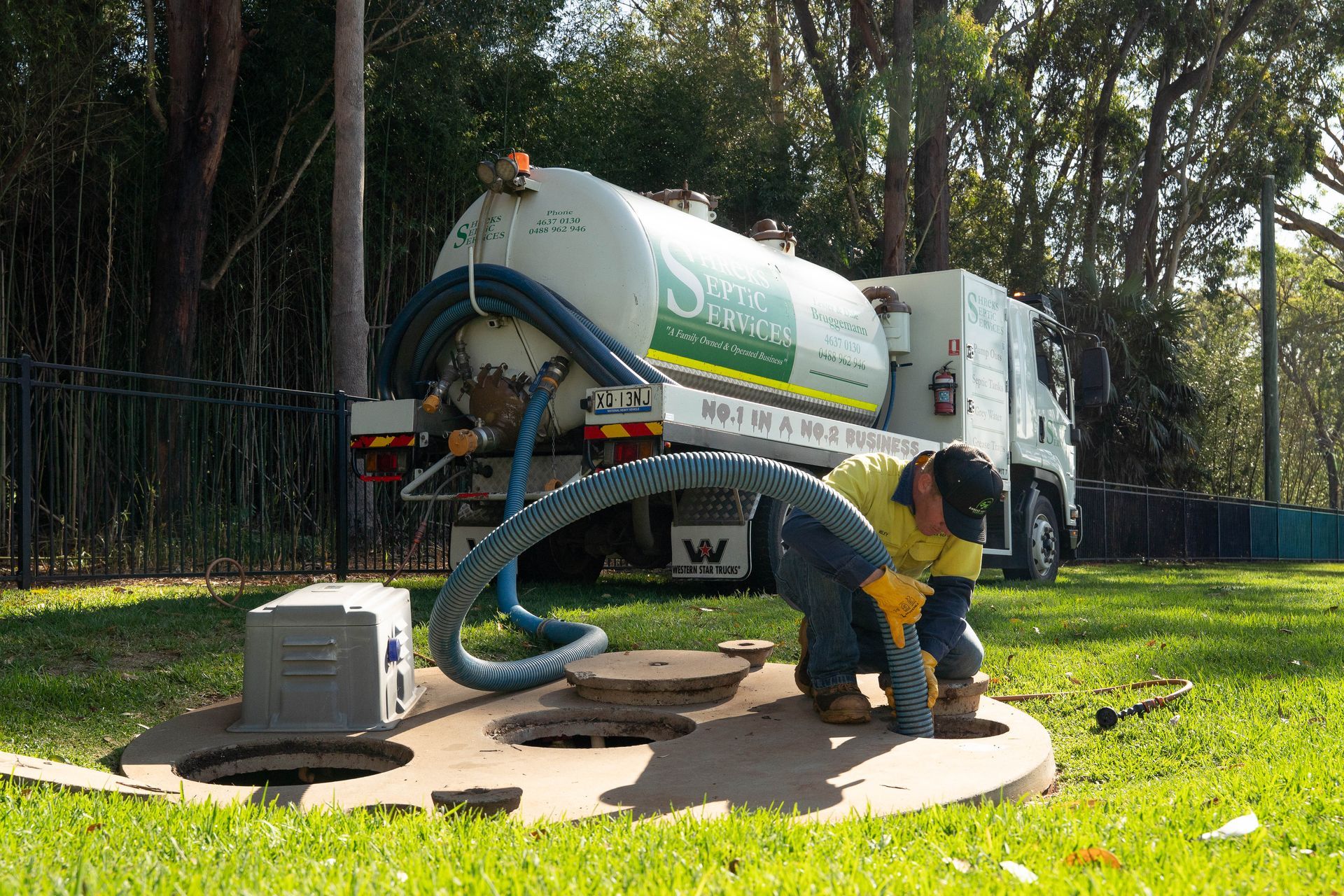 Worker Cleaning a Sewage Tank Beside a Truck — Shreks Septic Services in Gowrie Junction, QLD