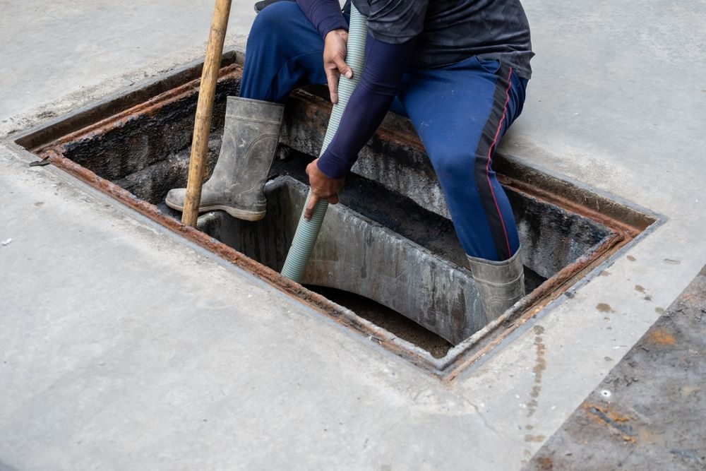 Workers Cleaning a Concrete Pit — Shreks Septic Services in Westbrook, QLD