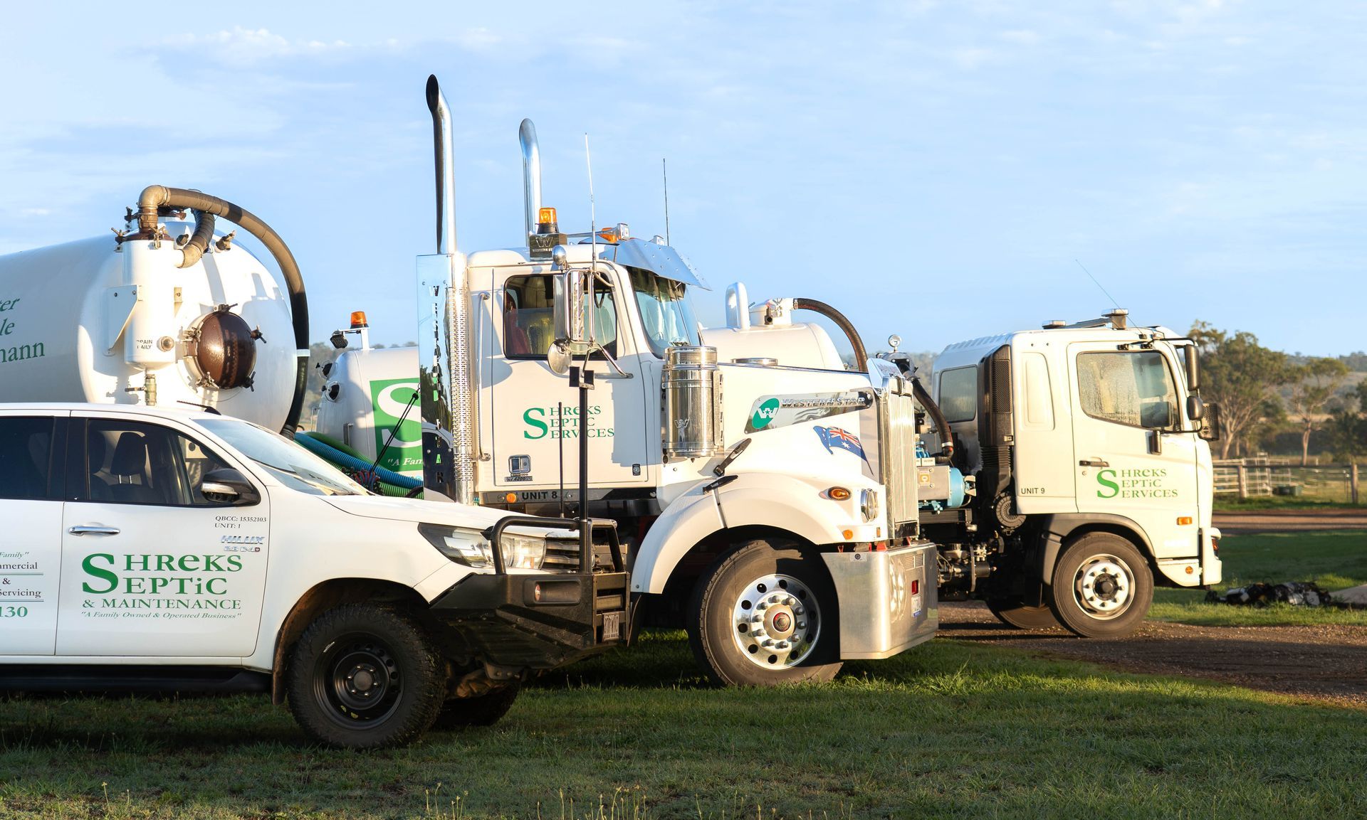 Two White Sewer Service Trucks Parked — Shreks Septic Services in Westbrook, QLD