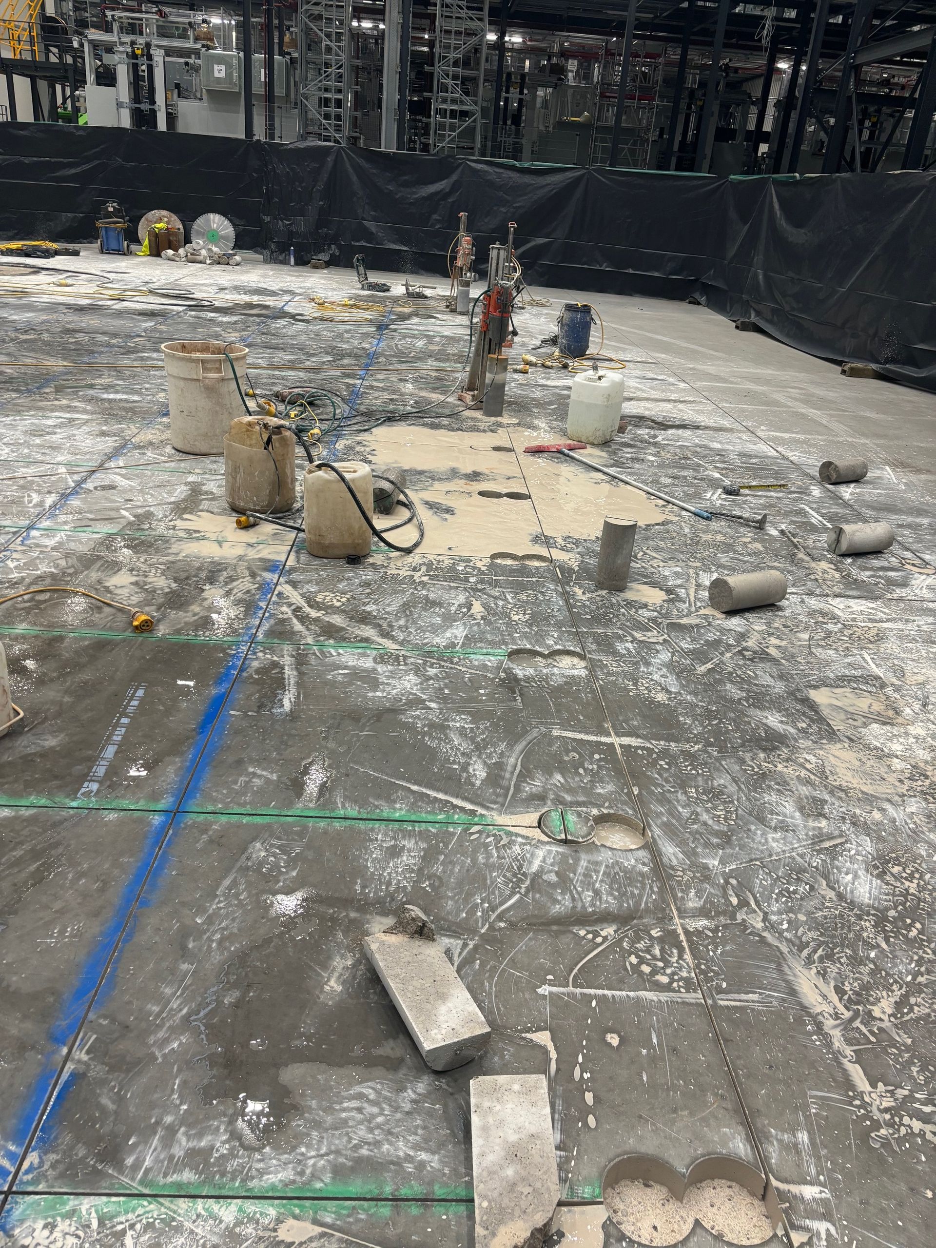 A construction site with a lot of concrete and buckets on the ground.
