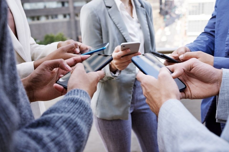 Networking, people and group with phone in hands typing email, reminder or sharing contact info. Business, community and team chat with professional social media, app or planning collaboration