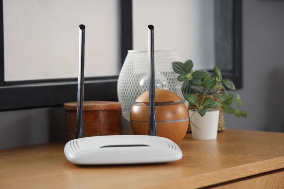 Modern wi-fi router on shelf in room, closeup