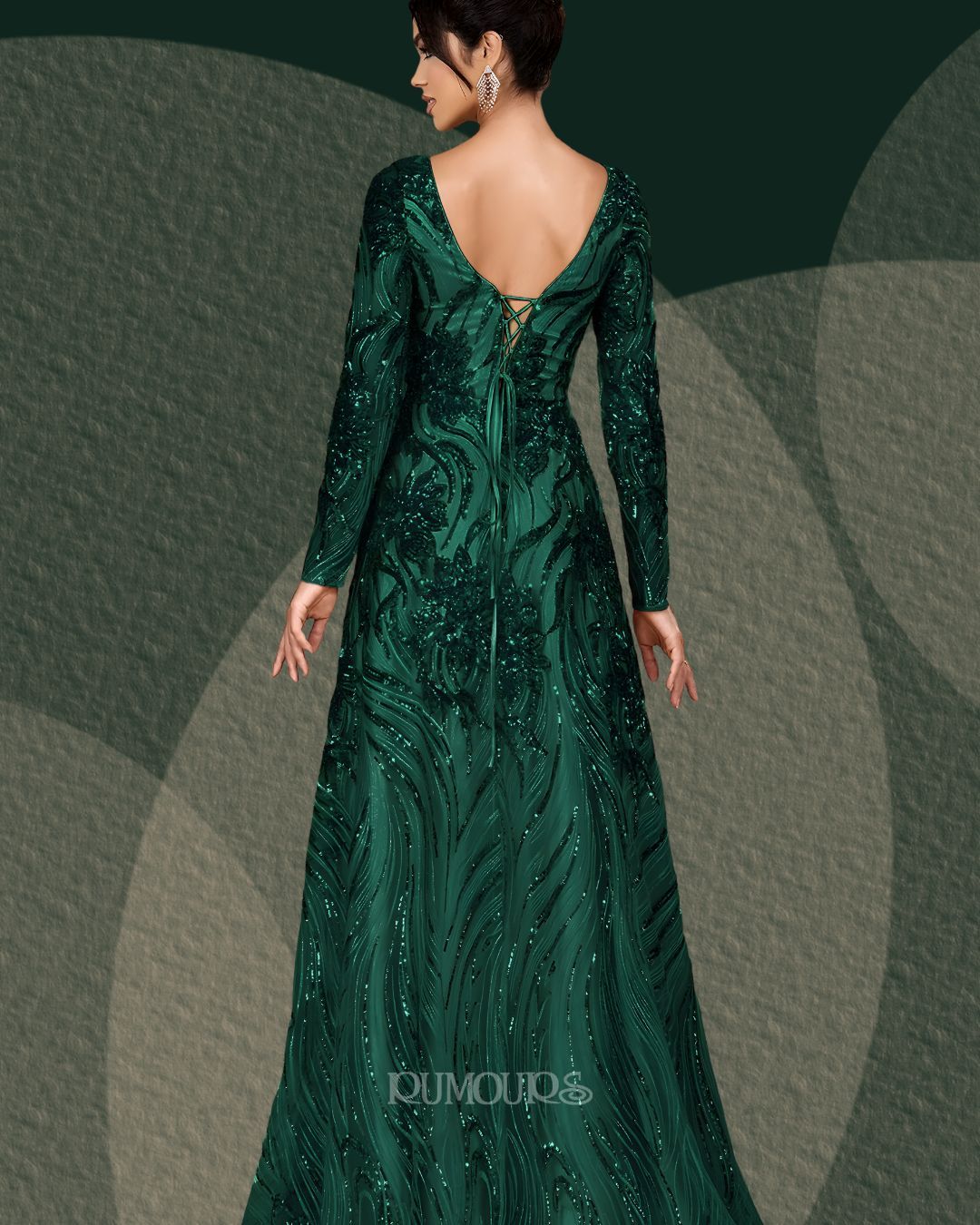 Woman in emerald green sequined evening gown with long sleeves and open back.