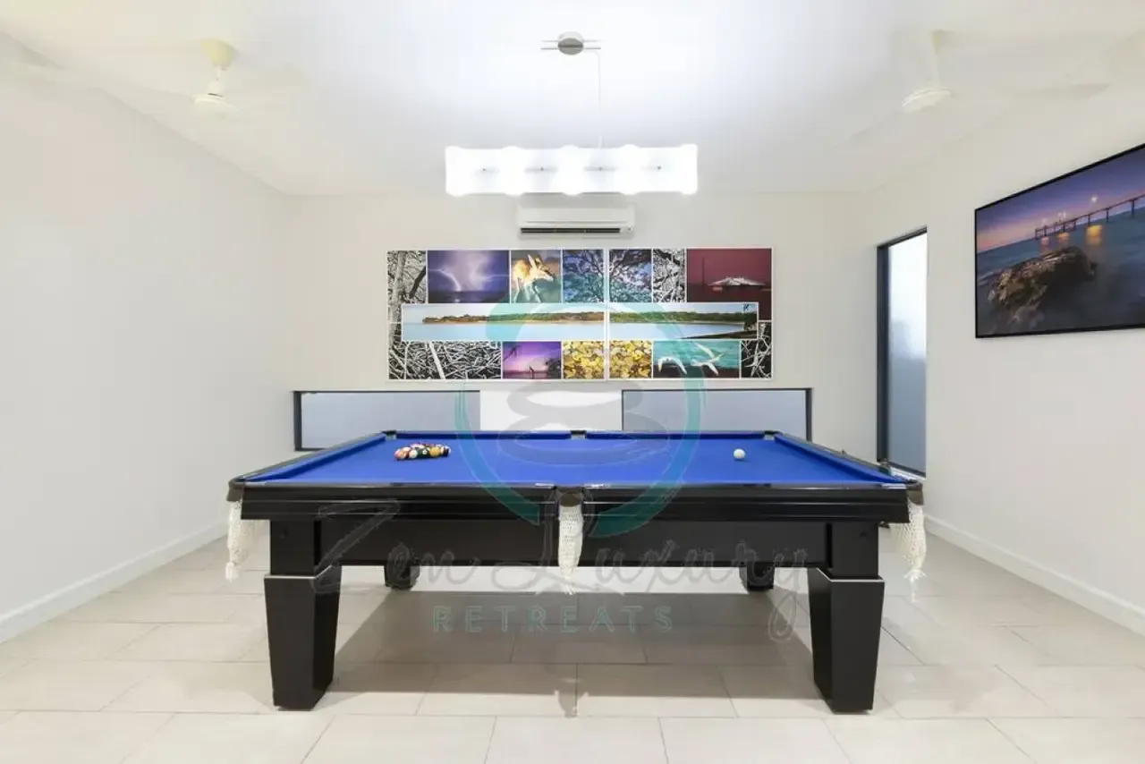 A Pool Table in a Room With Pictures on the Wall — Zen Luxury Retreats in Darwin City, NT