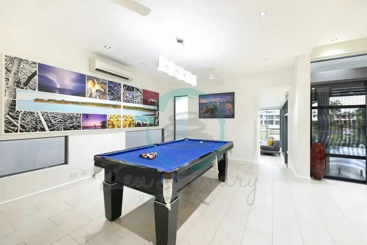 A Pool Table in a Room With Pictures on the Wall — Zen Luxury Retreats in Darwin City, NT