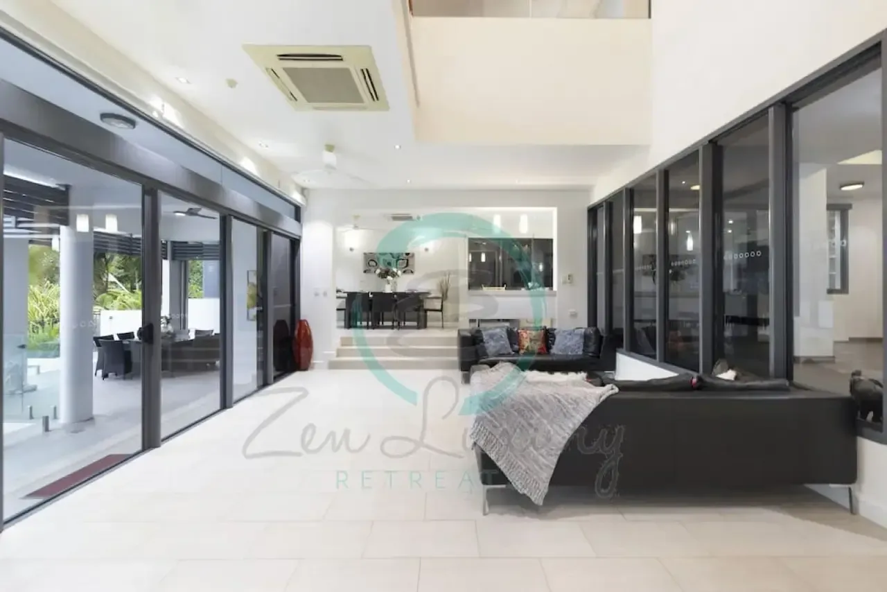 A Living Room With a Couch and a Lot of Windows — Zen Luxury Retreats in Darwin City, NT