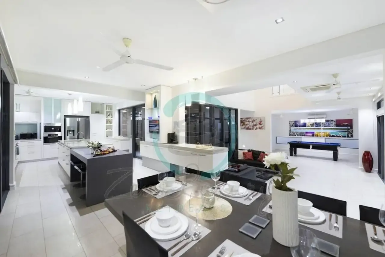 A Dining Room Table With a Vase of Flowers on It — Zen Luxury Retreats in Darwin City, NT