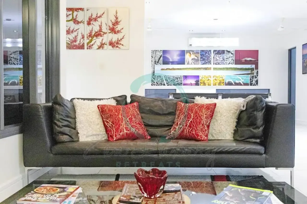 A Living Room With a Black Couch and Red Pillows — Zen Luxury Retreats in Darwin City, NT