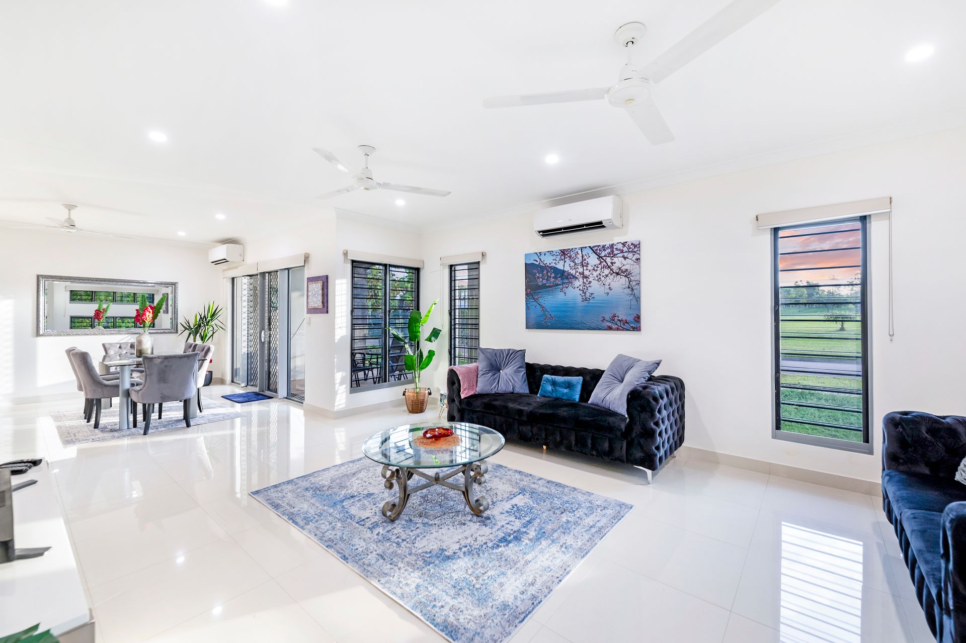 A Living Room With a Couch, Table, Chairs and a Ceiling Fan — Zen Luxury Retreats in Darwin City, NT