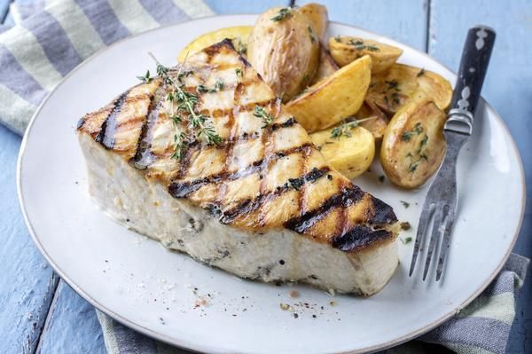 A White Plate Topped With a Piece of Grilled Fish — Zen Luxury Retreats in Darwin City, NT