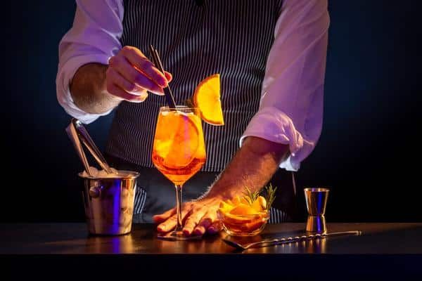 Bartender Adding Straws Aperol Spritz — Zen Luxury Retreats in Darwin City, NT