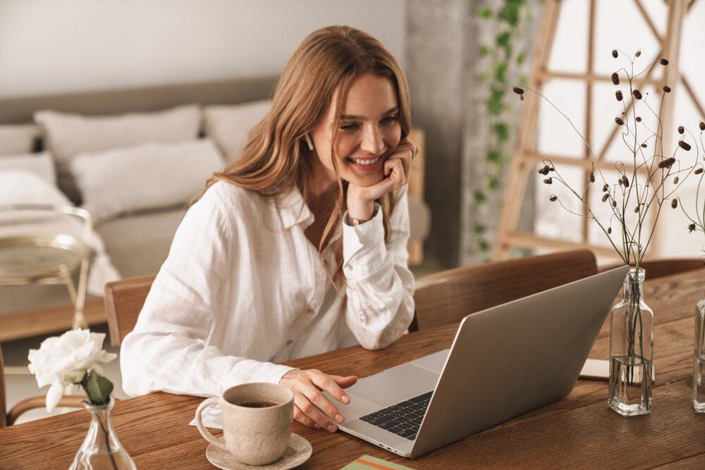 A Woman is Sitting at a Desk Using a Laptop Computer — Zen Luxury Retreats in Darwin City, NT