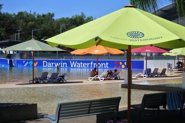 A Swimming Pool at Darwin Waterfront With Umbrellas and Chairs — Zen Luxury Retreats in Darwin City,