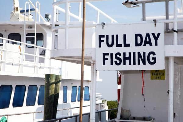 A Boat With Fishing Rods Attached to It is in the Water — Zen Luxury Retreats in Darwin City, NT