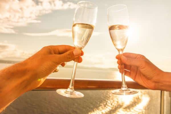 Two People Are Toasting with Champagne Glasses on A Balcony — Zen Luxury Retreats in Darwin City, NT