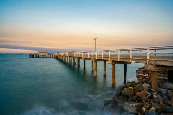 A Pier Leading Into the Ocean at Sunset — Zen Luxury Retreats in Darwin City, NT