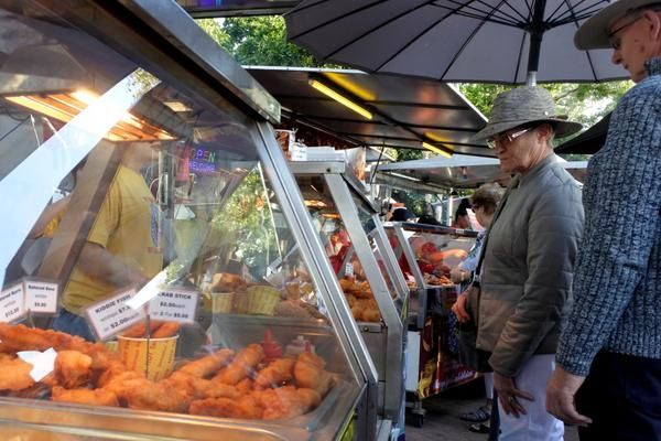 A Man in a Hat is Looking at Food in a Display Case — Zen Luxury Retreats in Darwin City, NT