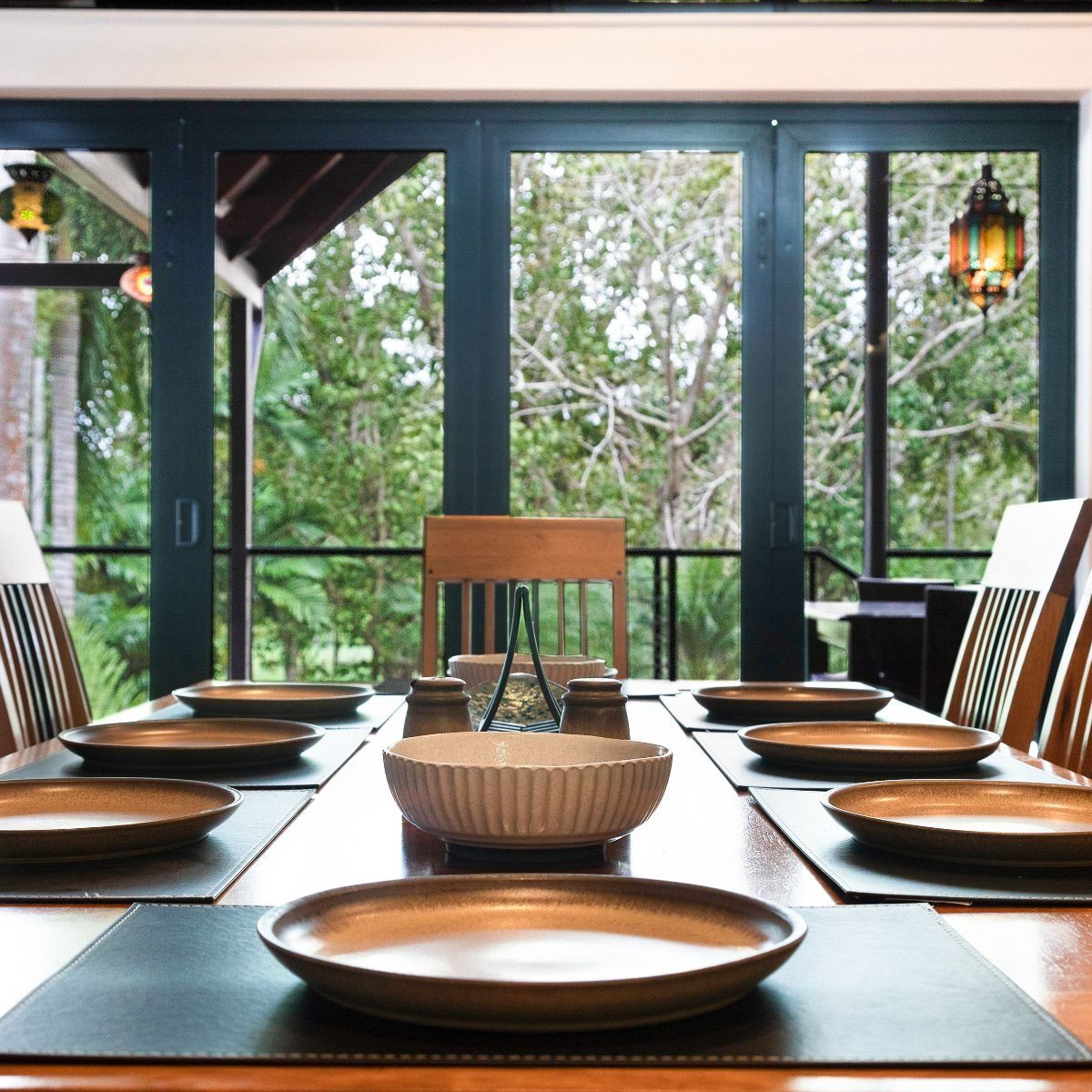 A Dining Room Table With Plates and a Bowl on It — Zen Luxury Retreats in Darwin City, NT