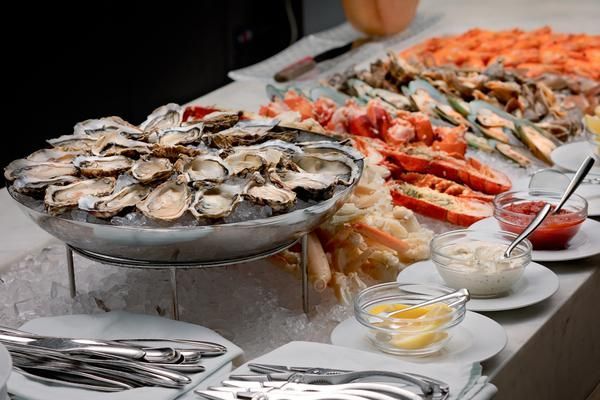 A Table Topped with A Variety of Seafood Including Oysters , Lobsters and Shrimp — Zen Luxury Retreats in Darwin City, NT