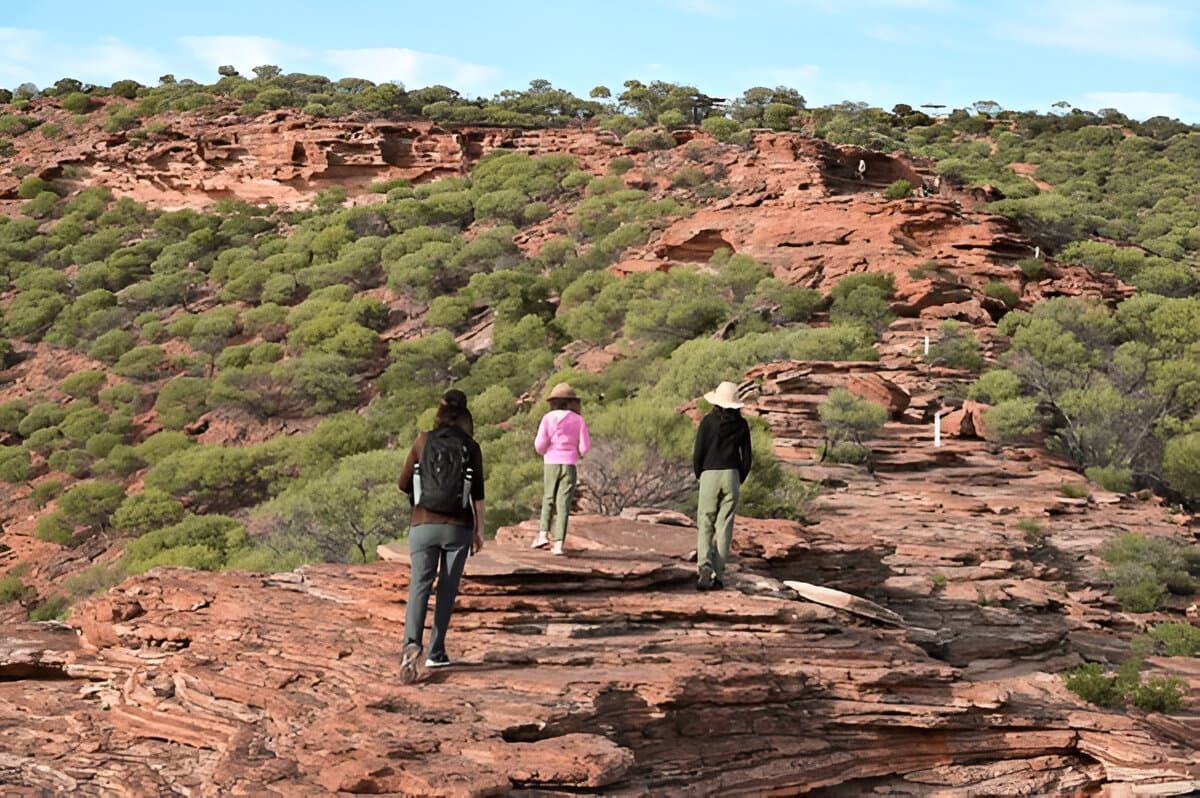 Three People Are Walking on a Rocky Hillside — Zen Luxury Retreats in Darwin City, NT