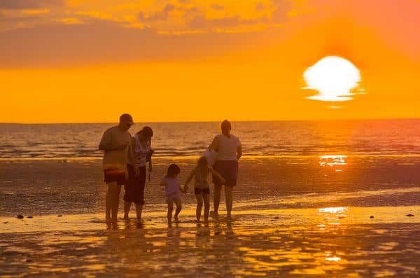 A Family Is Walking on The Beach at Sunset — Zen Luxury Retreats in Darwin City, NT