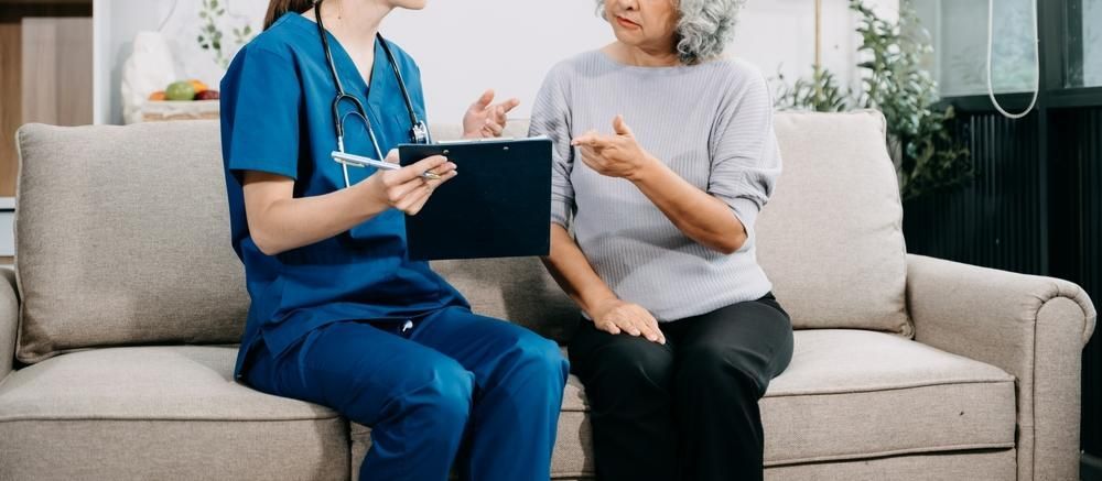 Nurse is Sitting on a Couch Talking to an Elderly Woman — Serenity Strides in Redbank Plains, QLD
