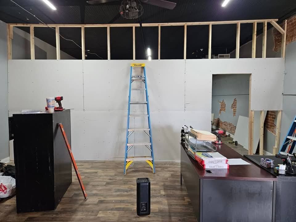 A ladder is sitting in the middle of a room under construction.