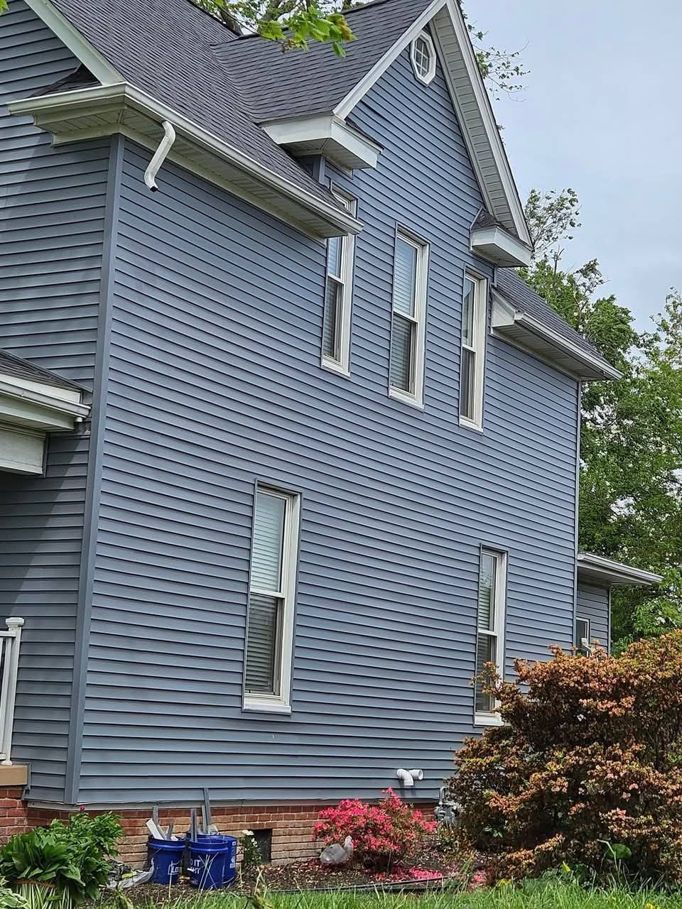 A large house with a gray siding and a gray roof