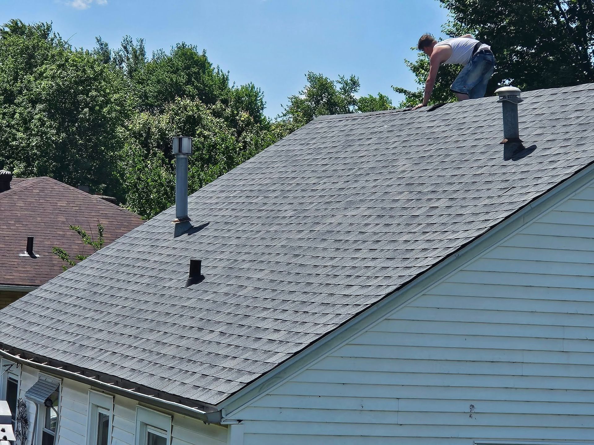 A man is working on the roof of a house.