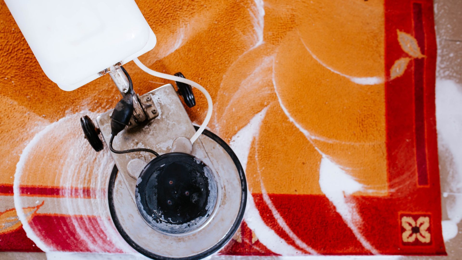 A camera is sitting on top of a red and white carpet.
