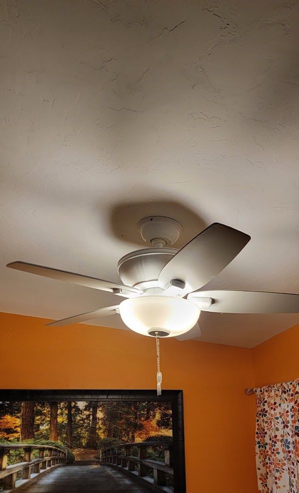 A ceiling fan is hanging from the ceiling of a room.