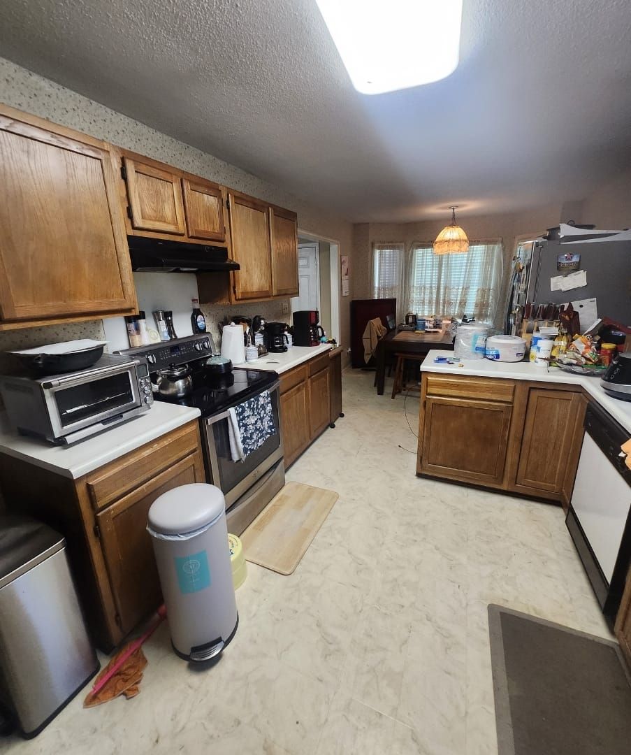 Kitchen with brown cabinets, appliances, and a table set for eating.