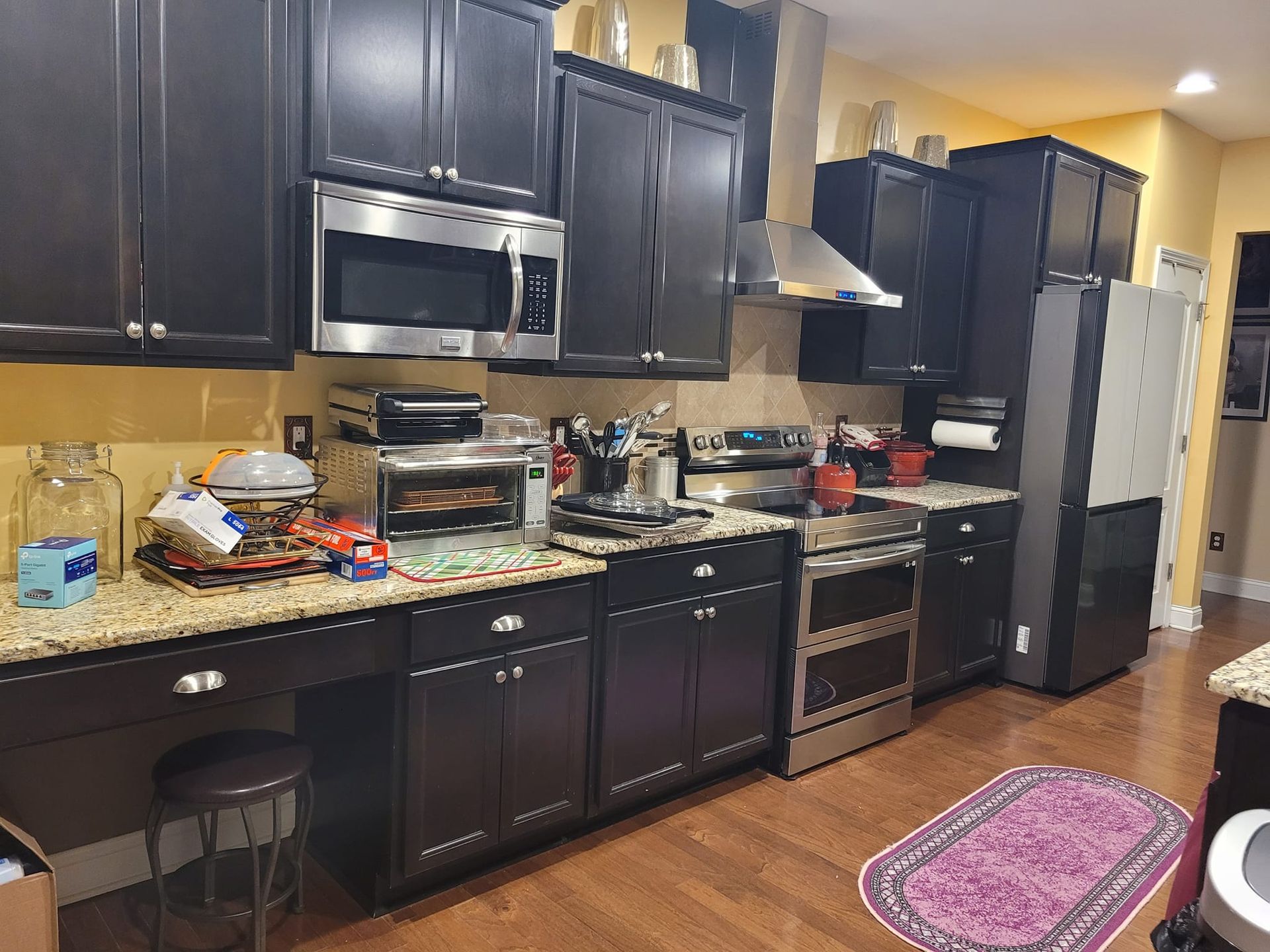 Dark brown kitchen cabinets, stainless steel appliances, granite countertops.