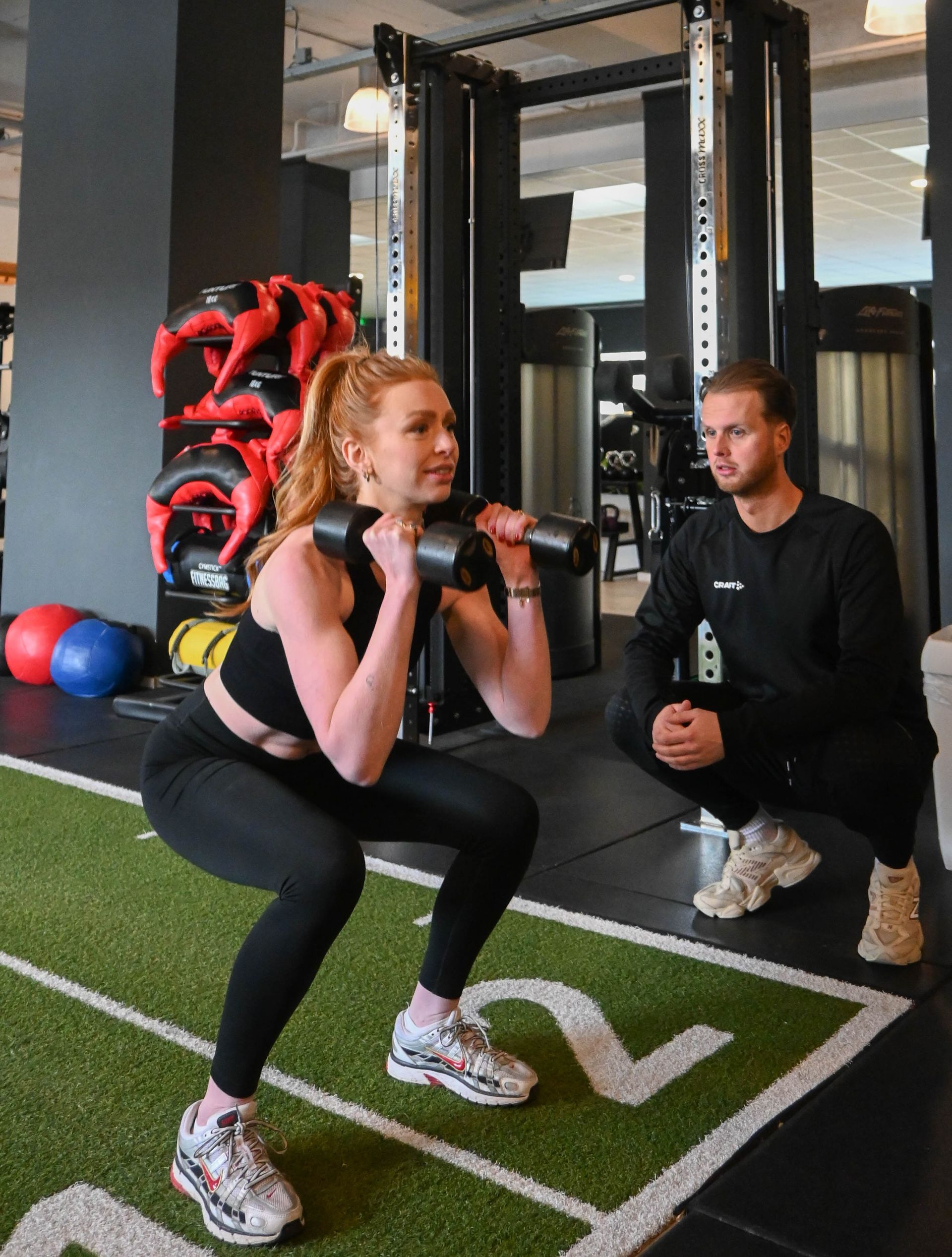 Een groep vrouwen doet squats in een sportschool.