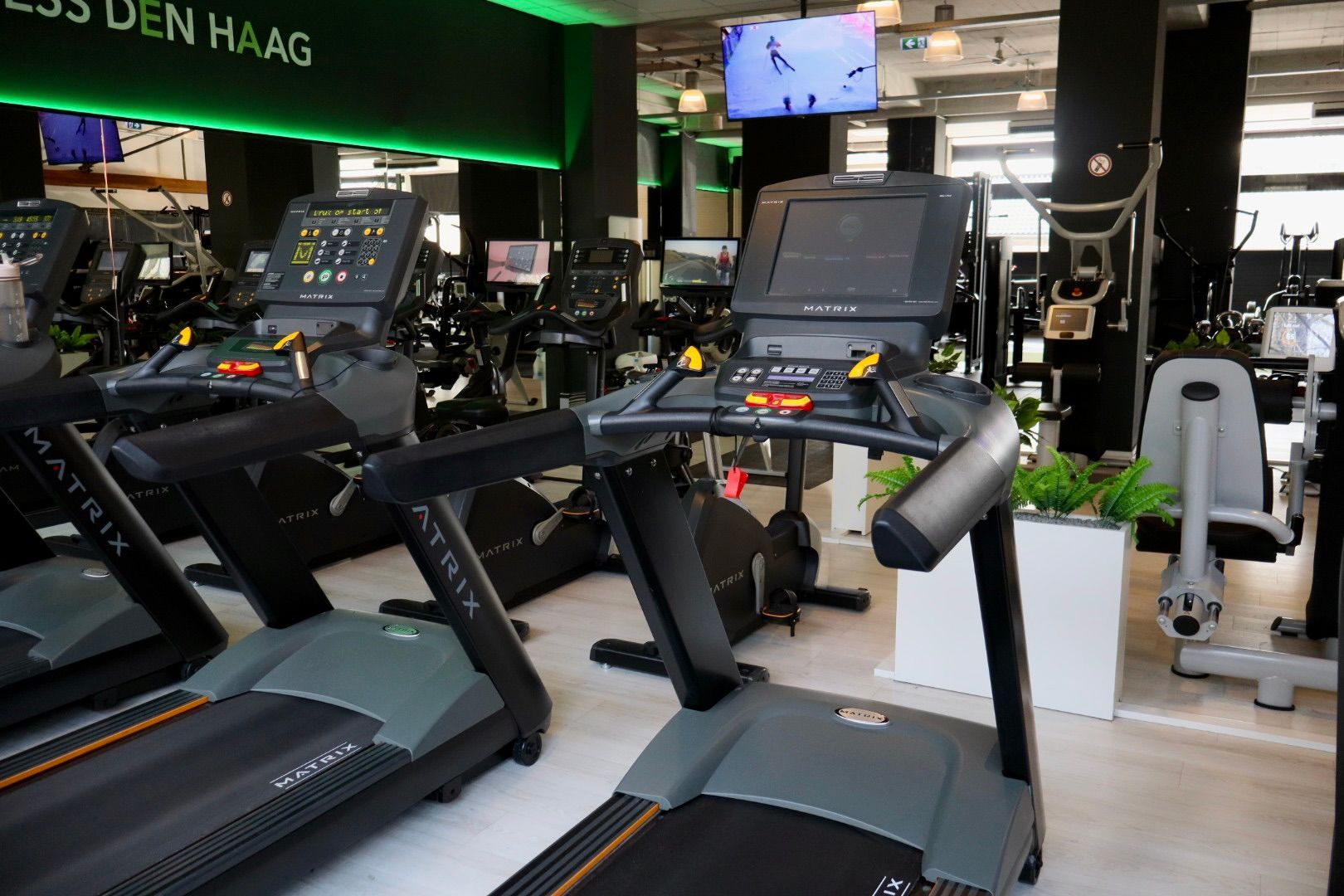 Een groep mensen fietst op een hometrainer in een sportschool.