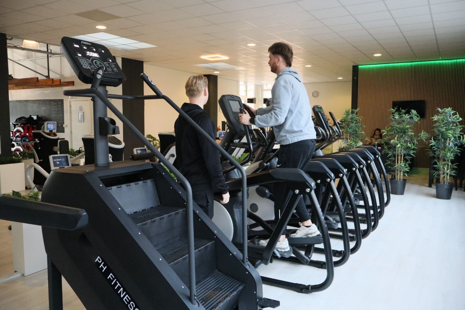 Een man tilt halters op een bankje in een sportschool.