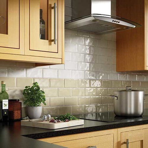 A kitchen with wooden cabinets , a stove top oven , a pot and a cutting board.