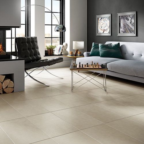 A living room with a couch , chair , coffee table and fireplace.