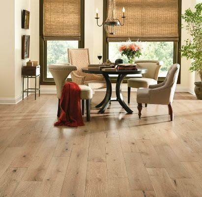 A dining room with hardwood floors and a table and chairs